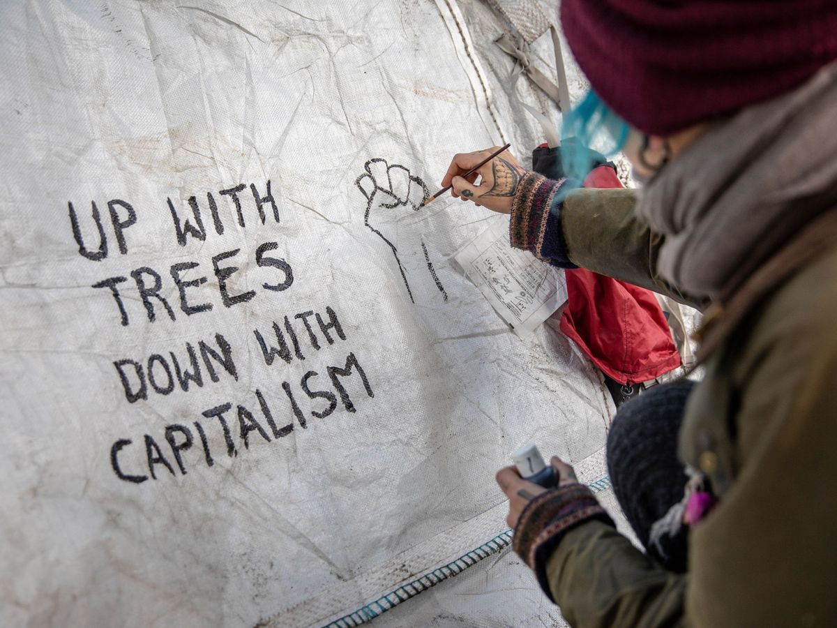 Foto: Activistas escriben "arriba con los árboles, abajo con el capitalismo" en unas protestas en Berlín. (Reuters)