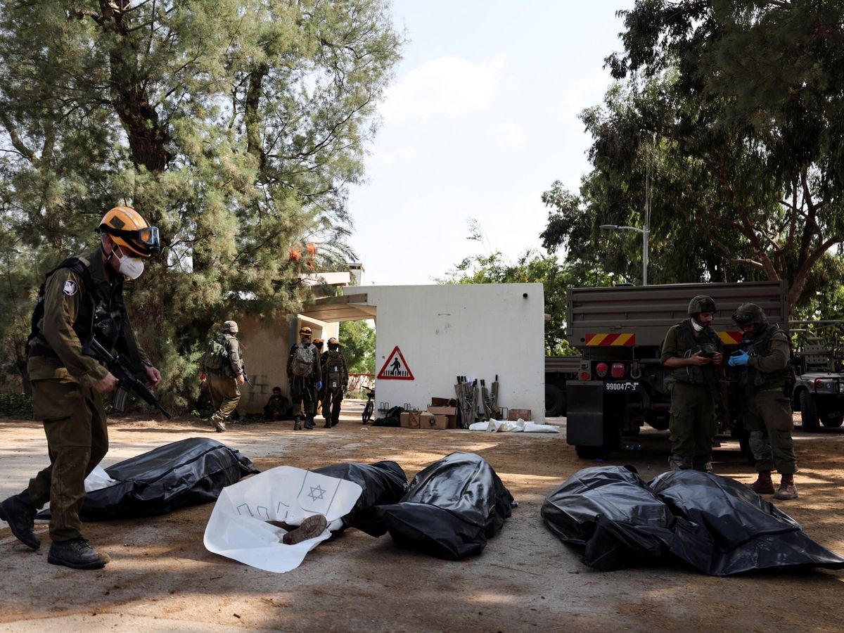 Foto: Soldados israelíes transportan los cuerpos de las víctimas del kibutz Kfar Aza. (Reuters/Ronen Zvulun)