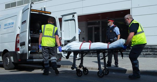 Foto: Miembros del servicio judicial retiran el cadáver del hombre que fue abatido al intentar acceder a la comisaría de los Mossos de Cornellà. (EFE)
