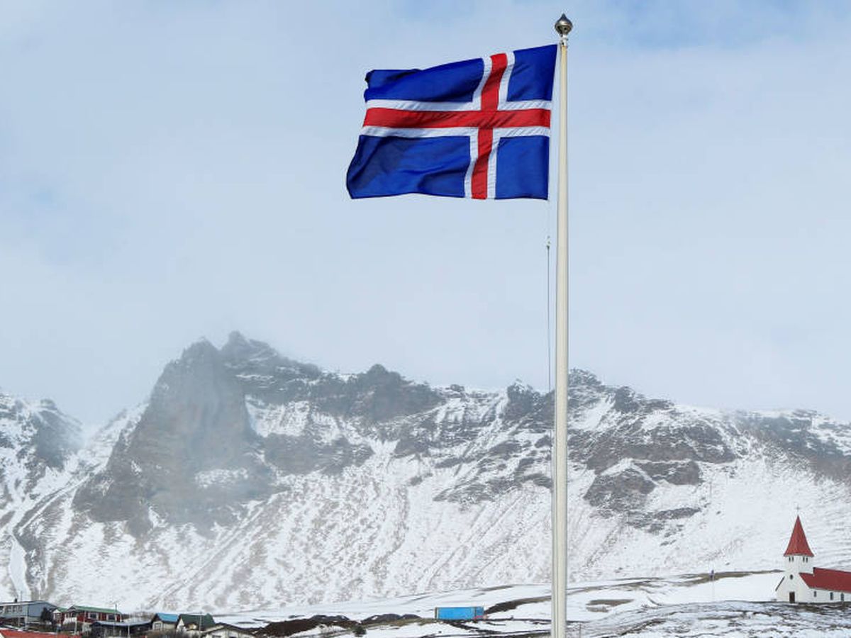 Foto: Bandera nacional de Islandia y una pequeña inglesia en Vik, Islandia (Reuters)