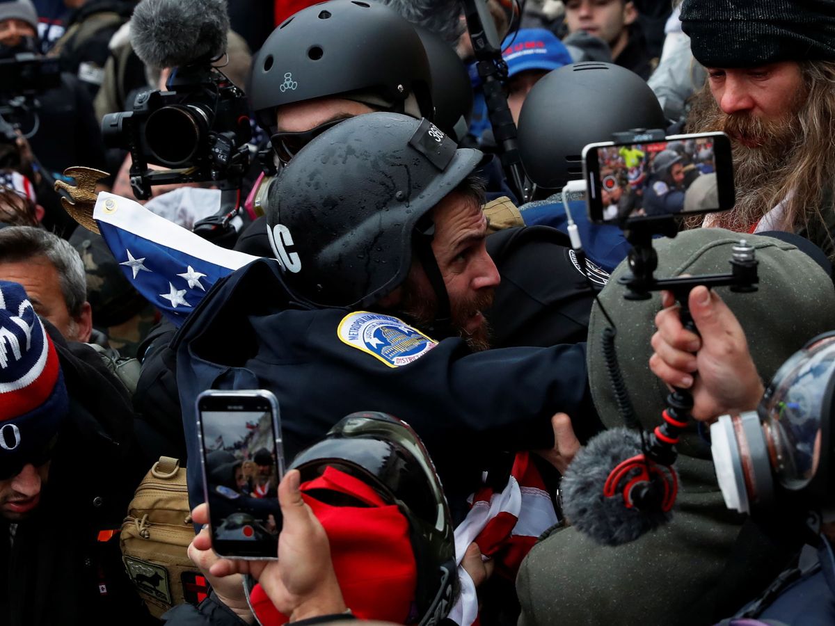 Foto: Golpistas seguidores de Trump asaltan el Capitolio mientras toman imágenes con sus móviles. (Reuters)