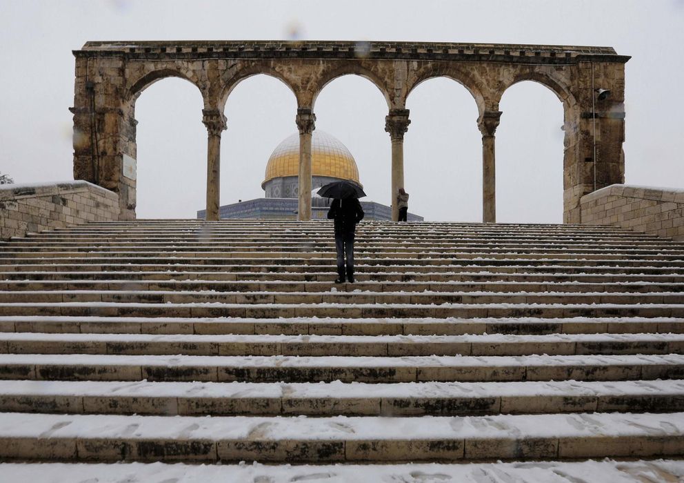 Foto: Un hombre con un paraguas frente a la Cúpula de la Roca en Jerusalén (Reuters).