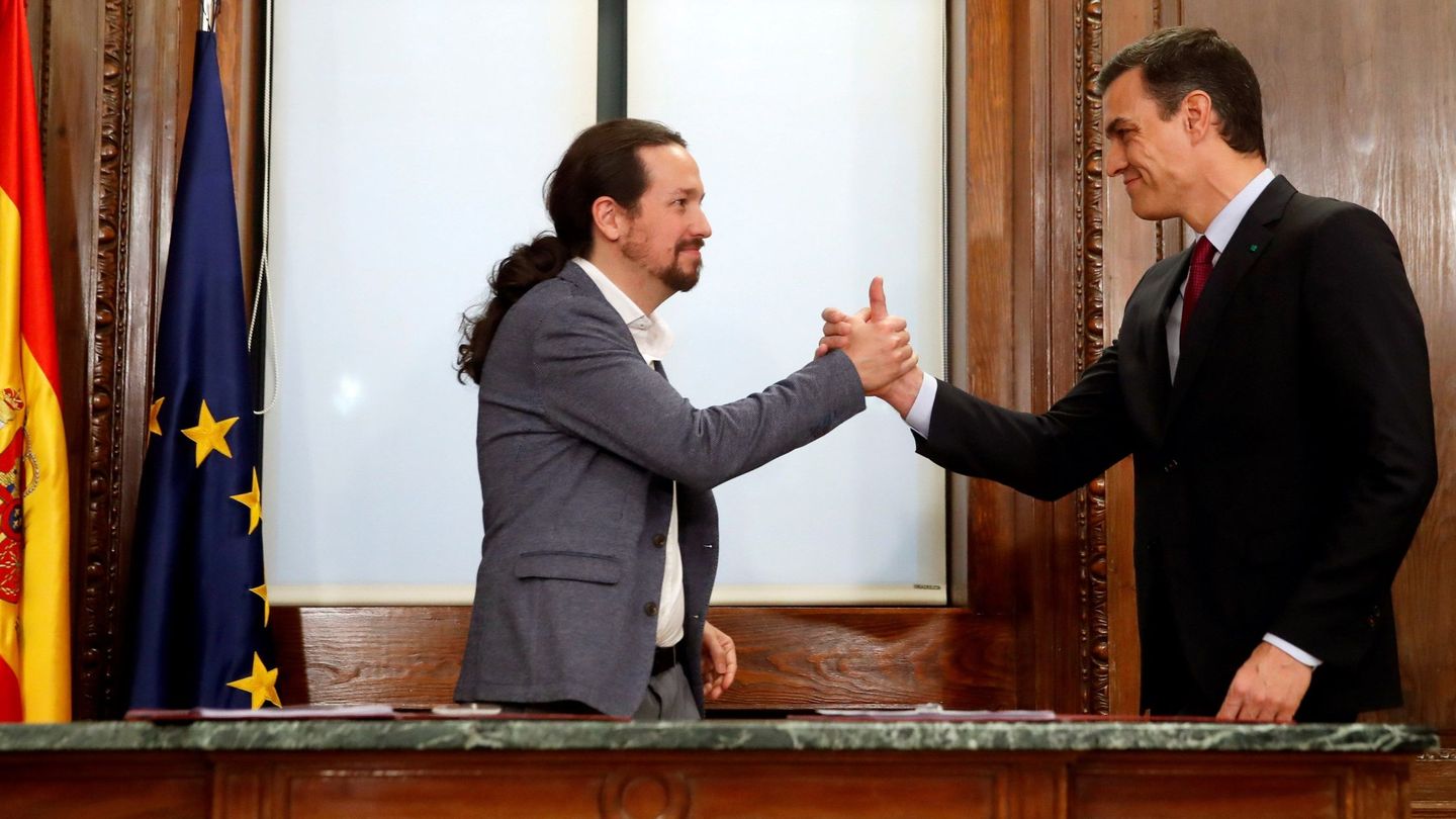 Pedro Sánchez y Pablo Iglesias estrechan sus manos tras rubricar su acuerdo programático de coalición, este 30 de diciembre en el Congreso. (EFE)
