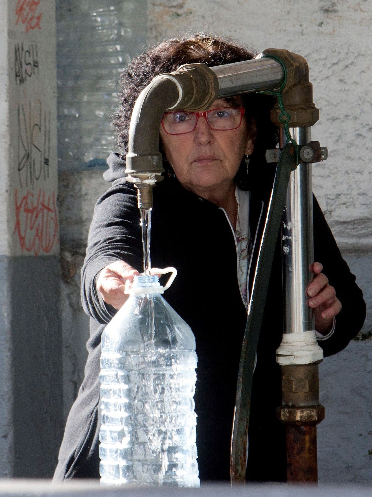 Una vecina de Vigo se abastece de agua potable. (EFE)