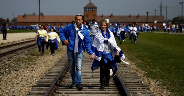 Foto: Una pareja camina sobre la vía de tren en el campo de concentración de Auschwitz-Birkenau, en Brzezinka, Polonia. (Reuters)