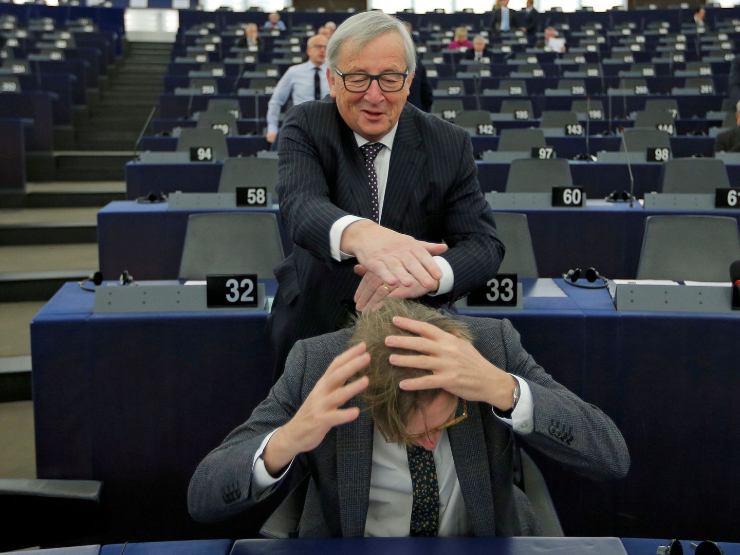 Juncker bromea con Guy Verhofstadt antes del debate en la Eurocámara. (Reuters)