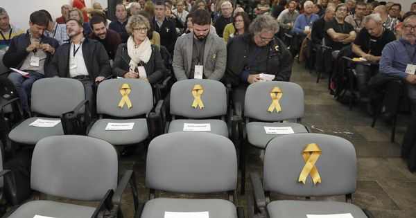 Foto: Lazos amarillos en las sillas vacías de los tres 'exconsellers' y el vicepresidente del Govern de ERC encarcelados. (EFE) 