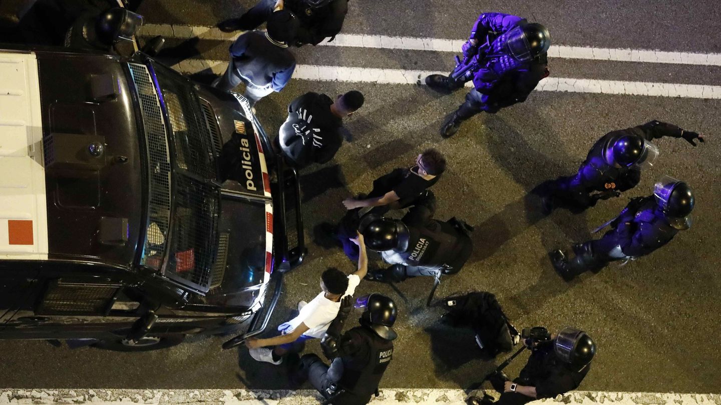Un grupo de policías proceden a registrar a dos jóvenes ayer en Barcelona. (EFE)