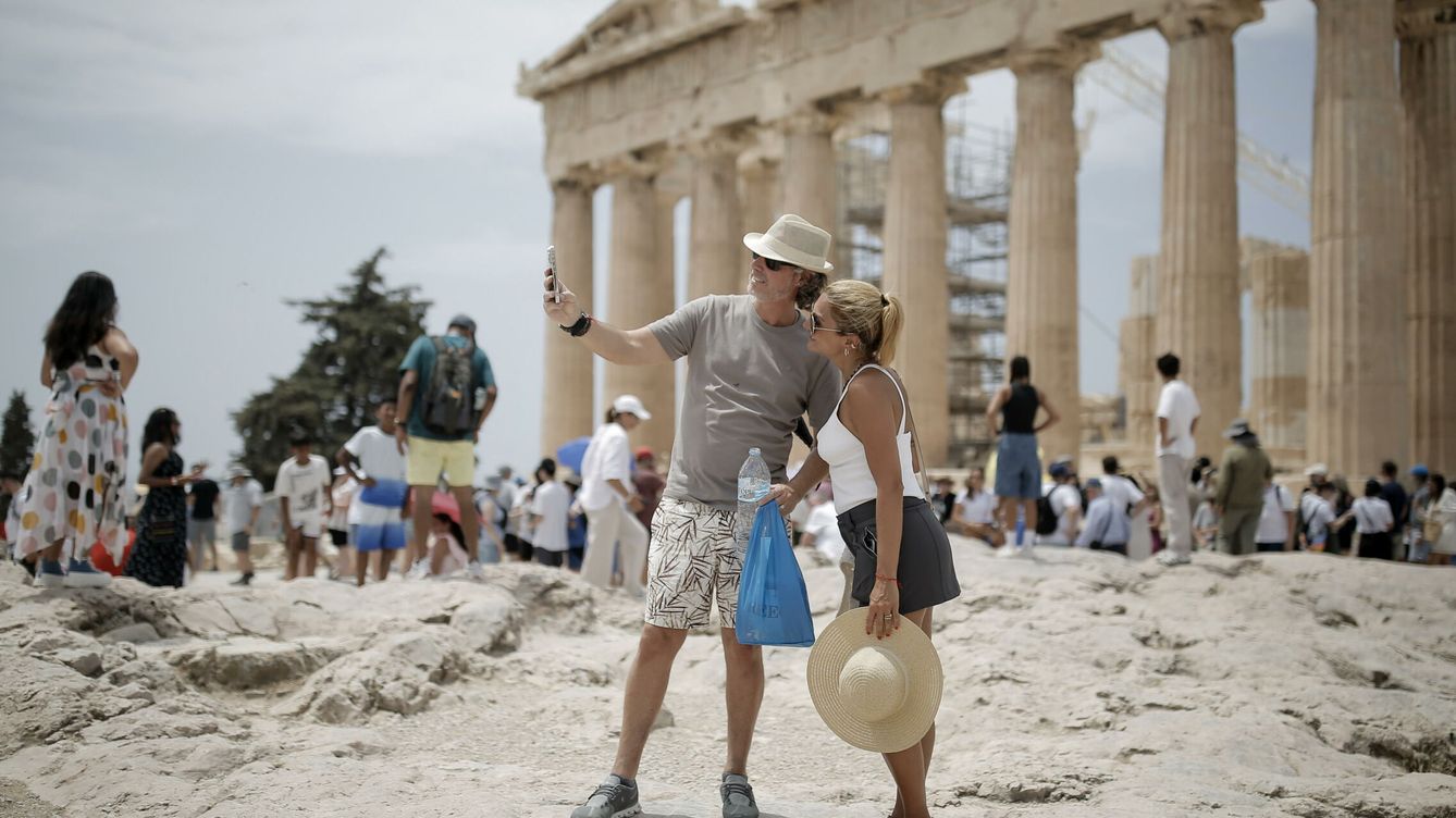 Foto: Una pareja de turistas visita la Acrópolis en Atenas, Grecia. (EFE/Kostas Tsironis)