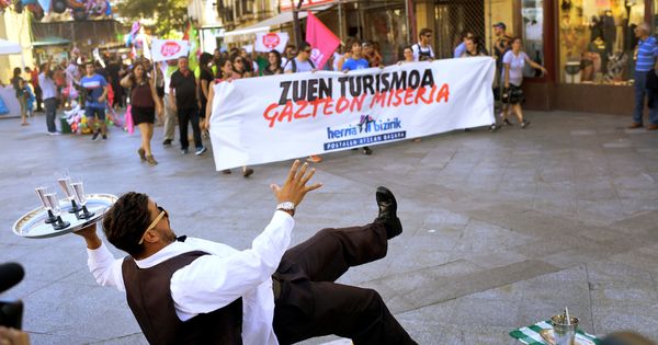 Foto: Las juventudes de Sortu se manifiestan contra el turismo en San Sebastián esta pasada Semana Grande junto a un artista callejero. (Reuters)