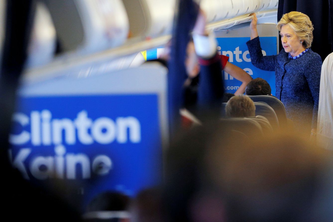 Hillary Clinton habla a miembros de su personal de campaña en un avión, el 28 de octubre de 2016 (Reuters)