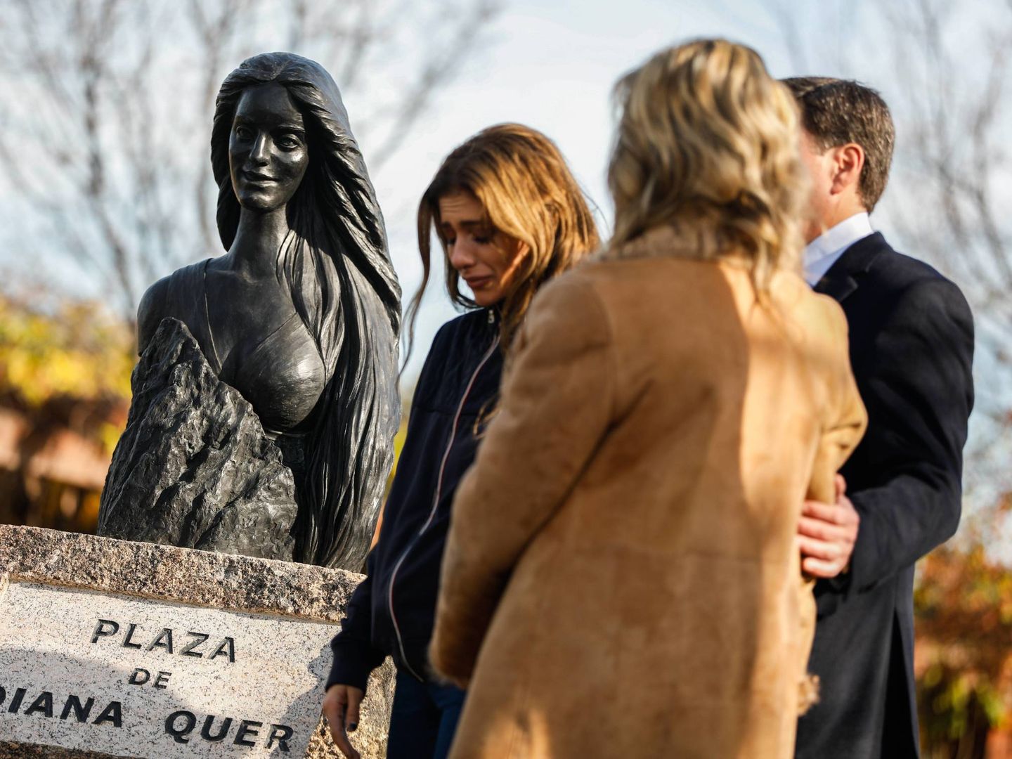 La hermana y los padres de Diana Quer junto a una estatua en su recuerdo. (Cordon Press)
