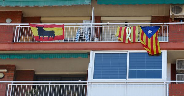 Foto: Banderas de España con el toro de Osborne y esteladas colgadas en los balcones de un edificio en Barcelona. (Reuters)
