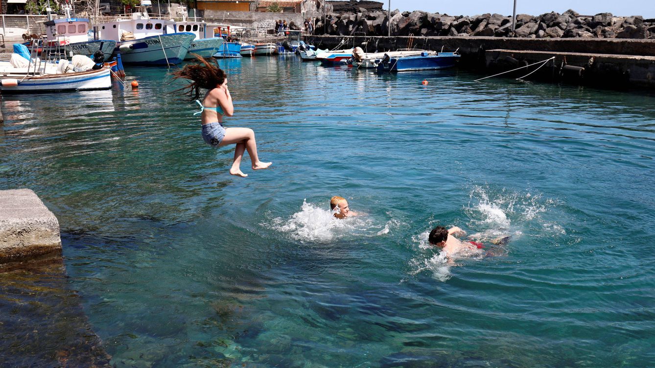 Foto: Niños juegan en el mar (Reuters)