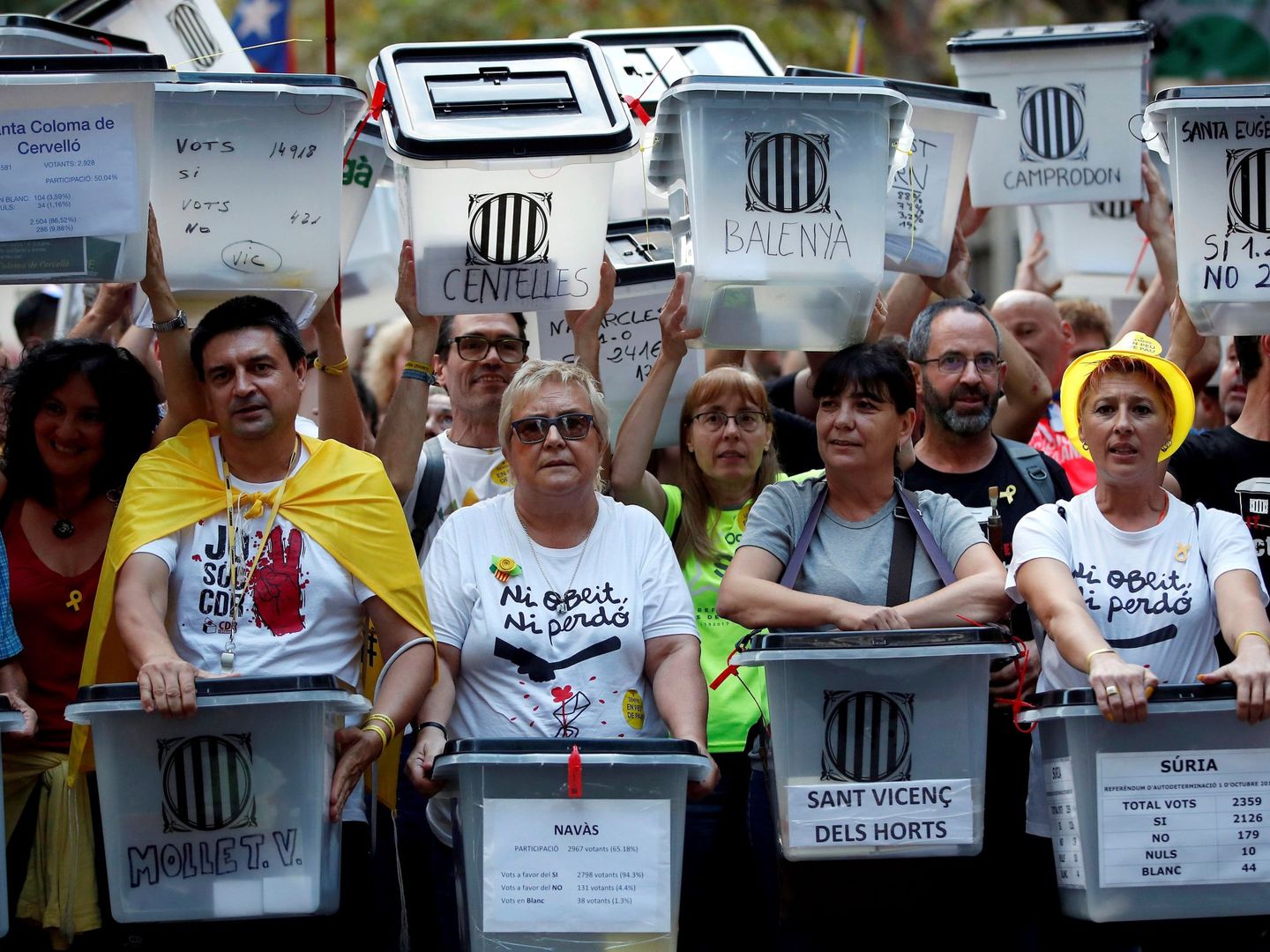 Manifestantes portan urnas en Barcelona con el nombre del municipio al que pertenecen. (EFE)