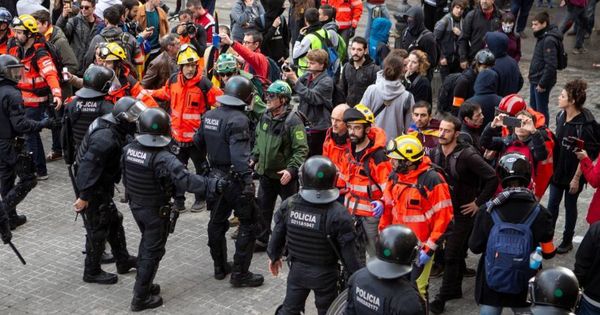 Foto: Bomberos montan un cordón entre 'mossos' y manifestantes para evitar incidentes. (EFE)