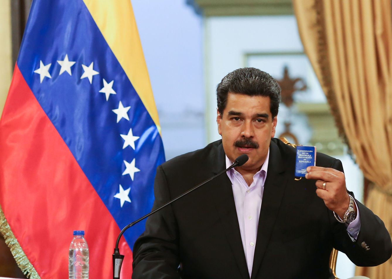 Nicolás Maduro enarbola una copia de la Constitución de Venezuela durante un encuentro con diplomáticos retirados de EEUU, en Caracas, el 29 de enero de 2019. (Reuters)