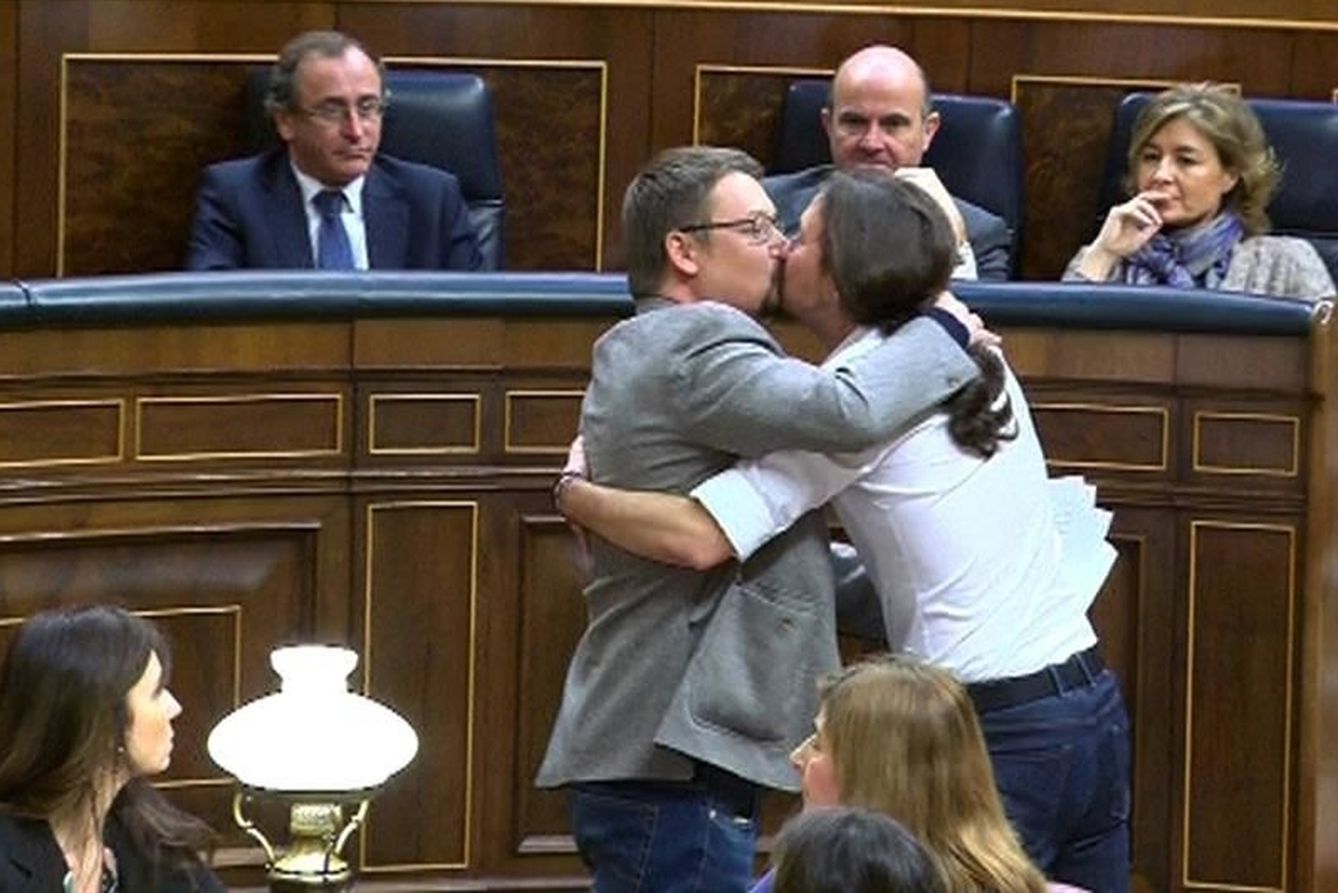 Beso del líder de Podemos, Pablo Iglesias, y del de En Comú Podem, Xavier Domènech. (EFE)