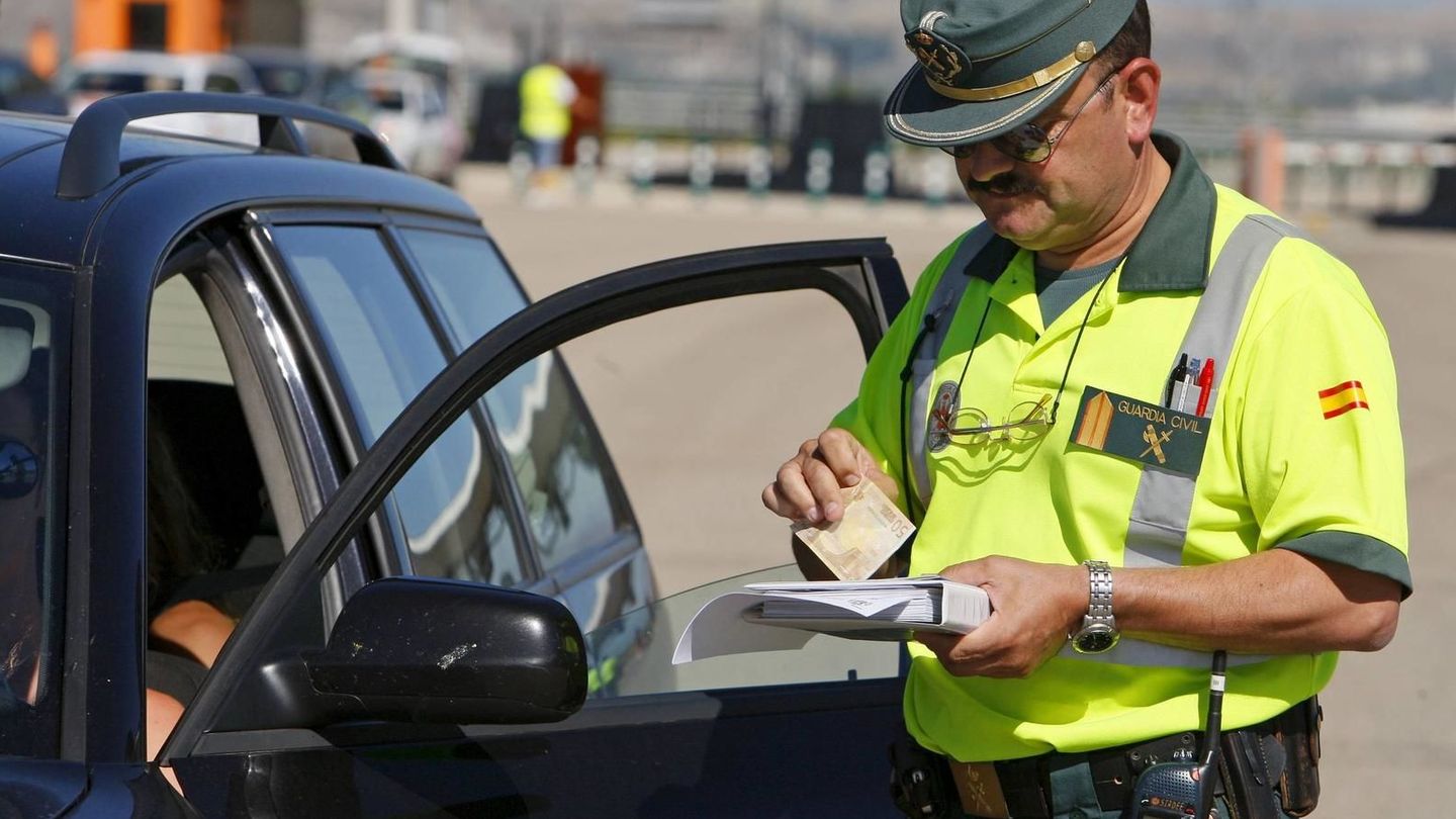 Un Guardia Civil impone una multa de tráfico a un conductor. (EFE)