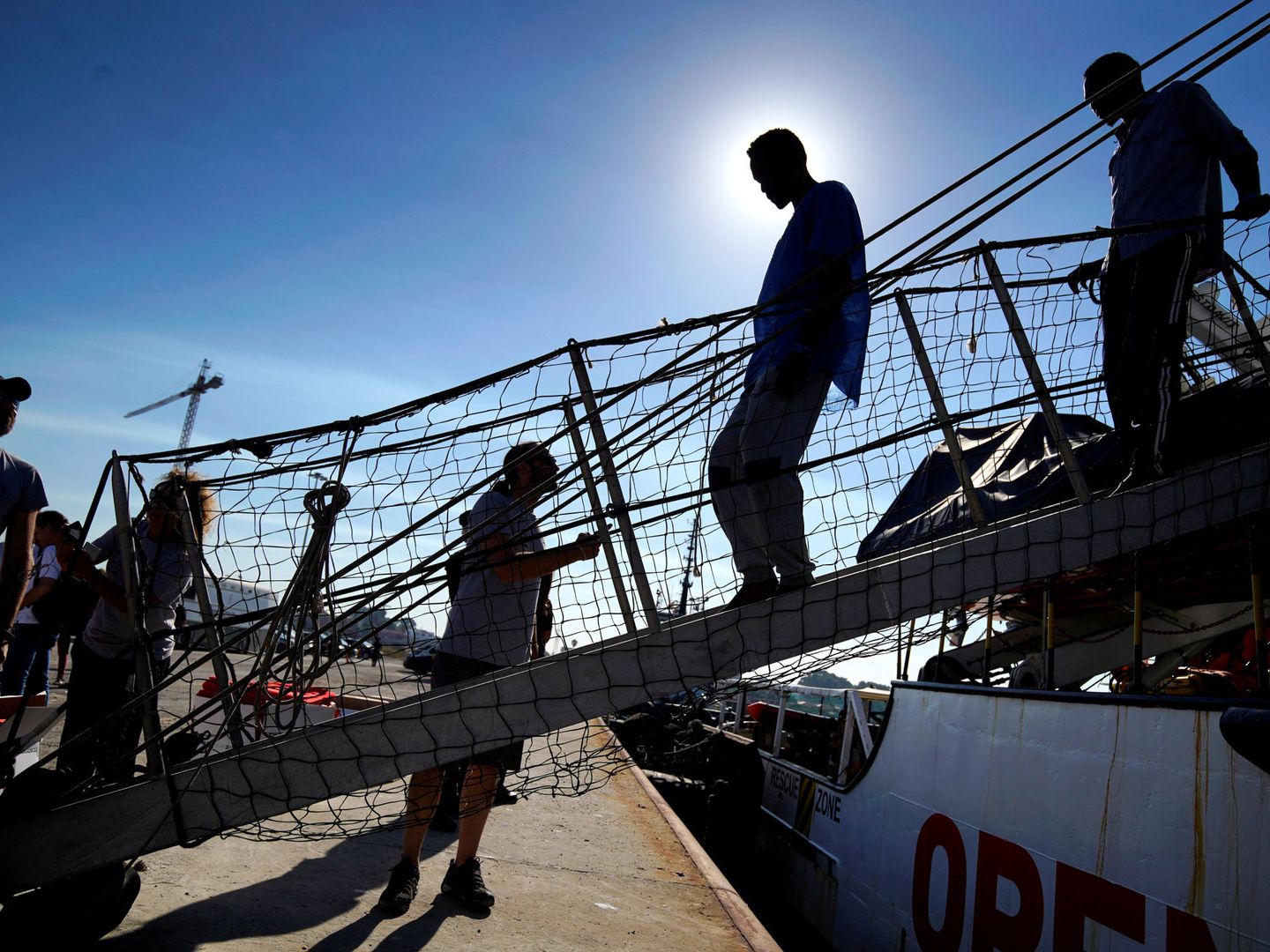 Migrantes bajan del Open Arms. (Reuters)