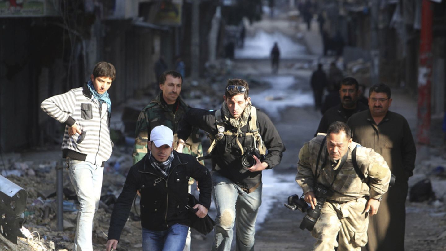 Bryn Karcha (c), de Canadá, y Toshifumi Fujimoto (d) de Japón corren en una calle de Alepo, Siria (Reuters).