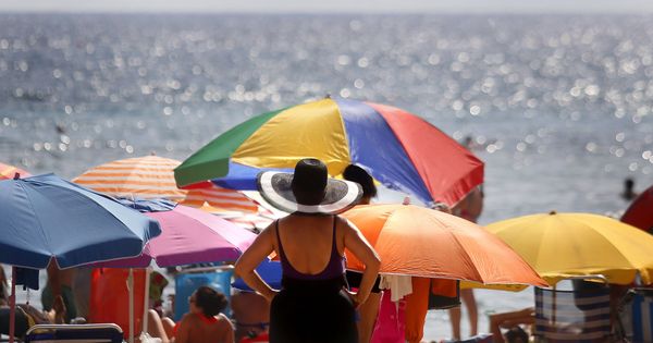 Foto: Varios turistas disfrutan del sol y el agua en la playa de Levante de Benidorm. (Efe)