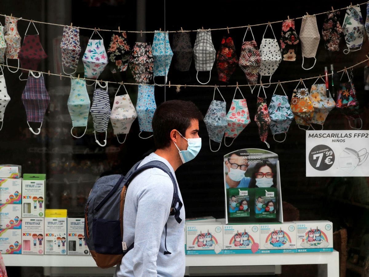Foto: Una persona pasea frente a una tienda de mascarillas. (Reuters) 