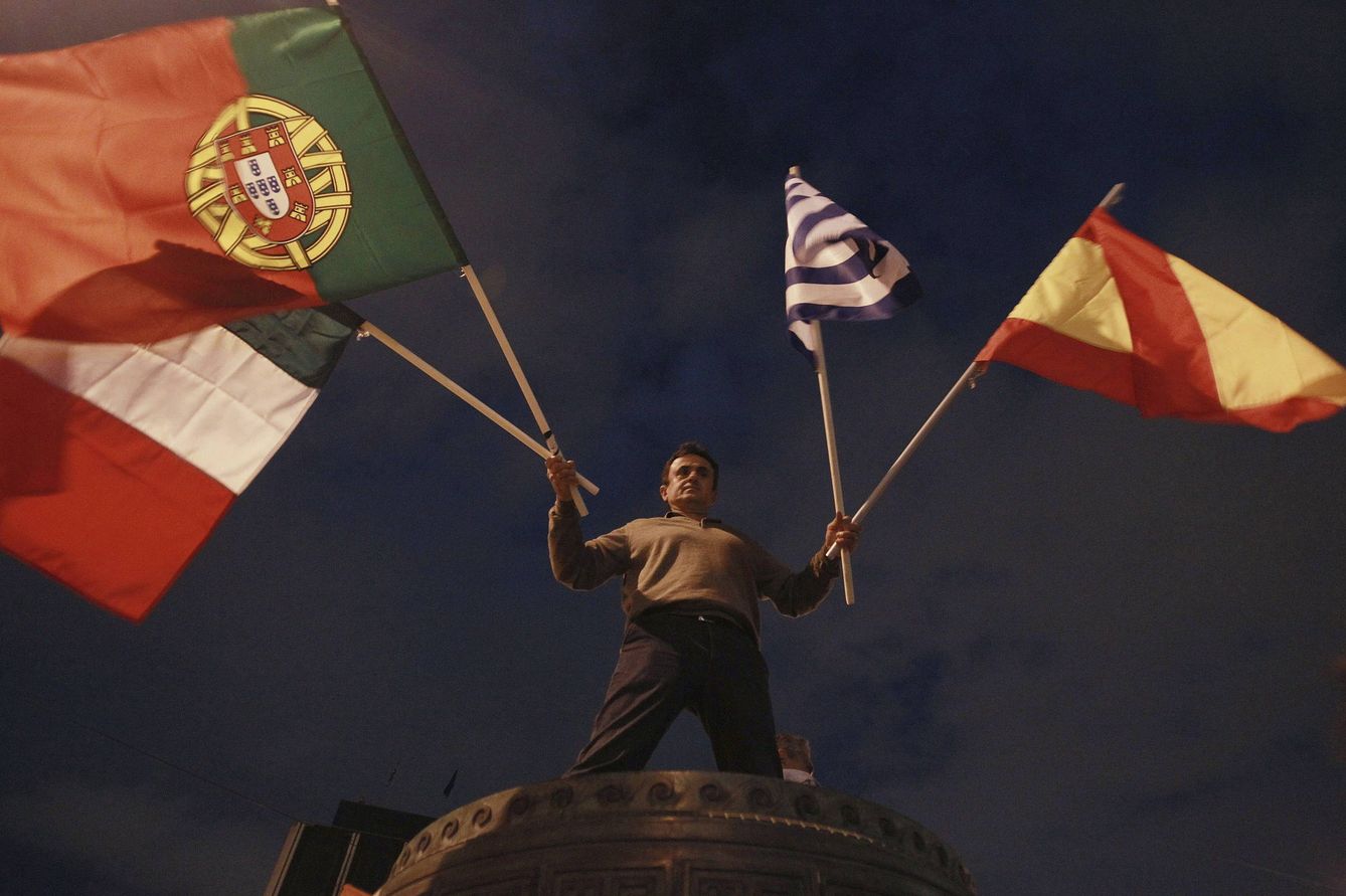 Foto: En Atenas, un manifestante ondea banderas de Italia, Portugal, Grecia y España (Efe)