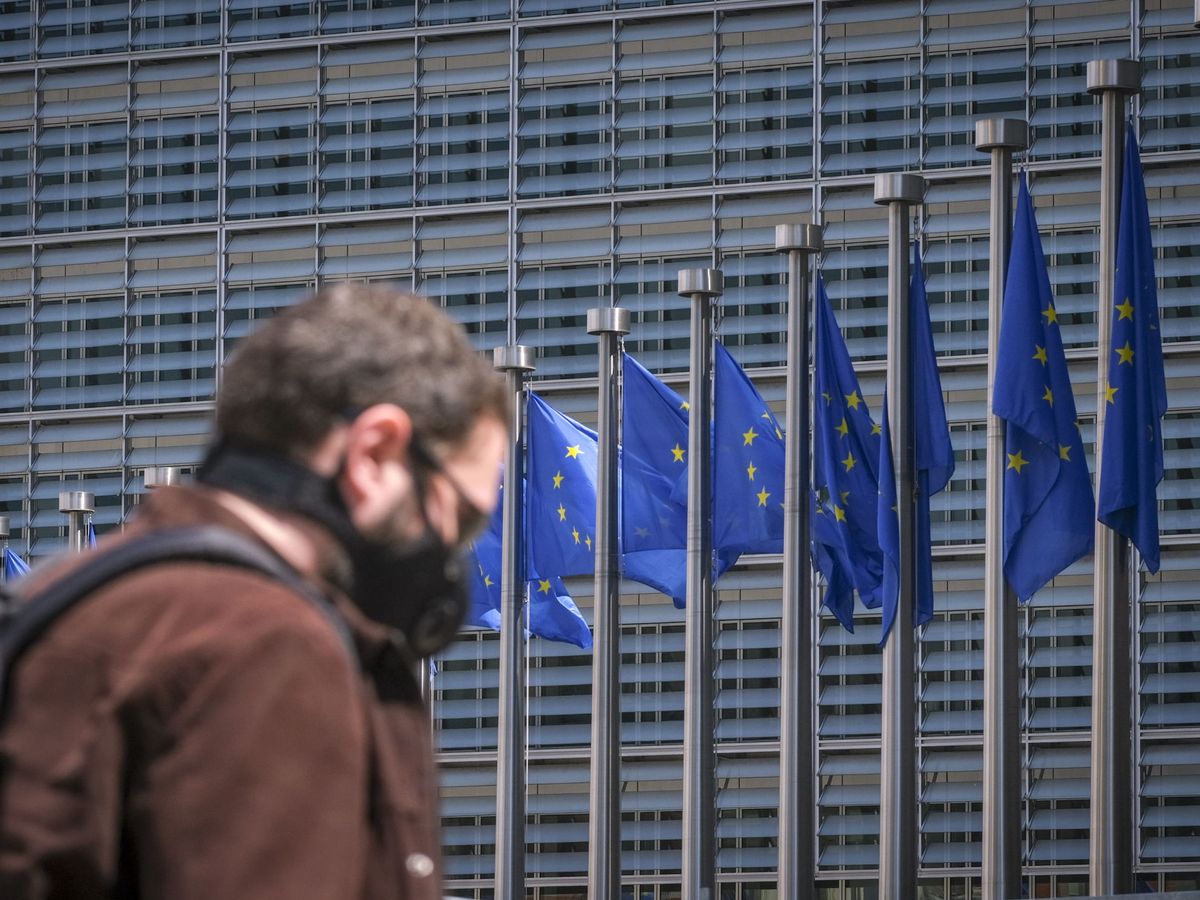 Foto: Un hombre pasea con una mascarilla frente a la sede de la Comisión Europea. (EFE)