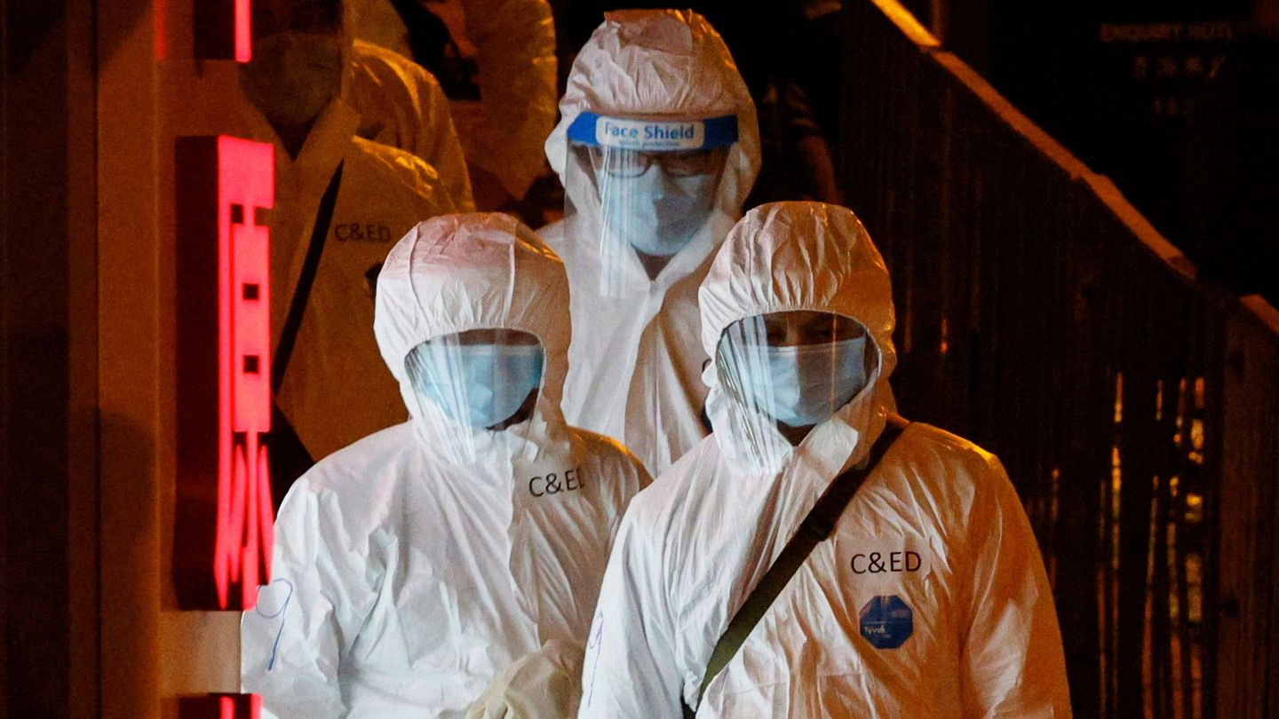 Trabajadores con trajes de protección para contener un nuevo brote en Hong Kong. (Reuters) 