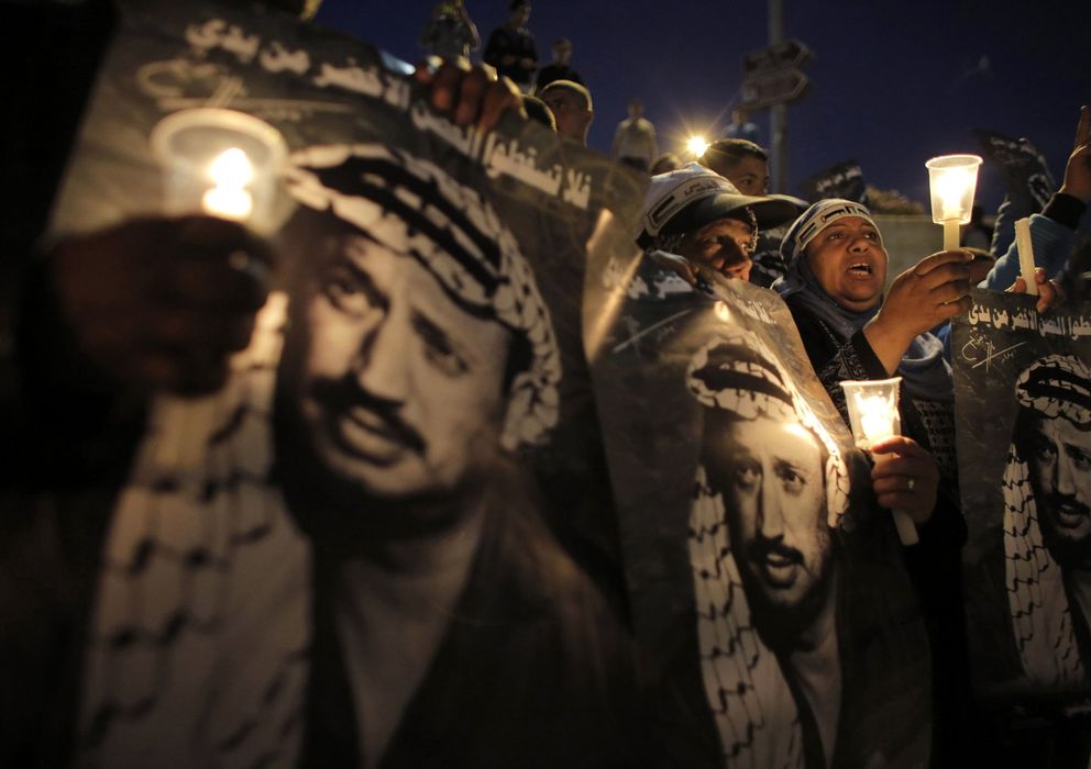Foto: Palestinos sostienen carteles con la imagen de Arafat en el aniversario de su muerte (Reuters).