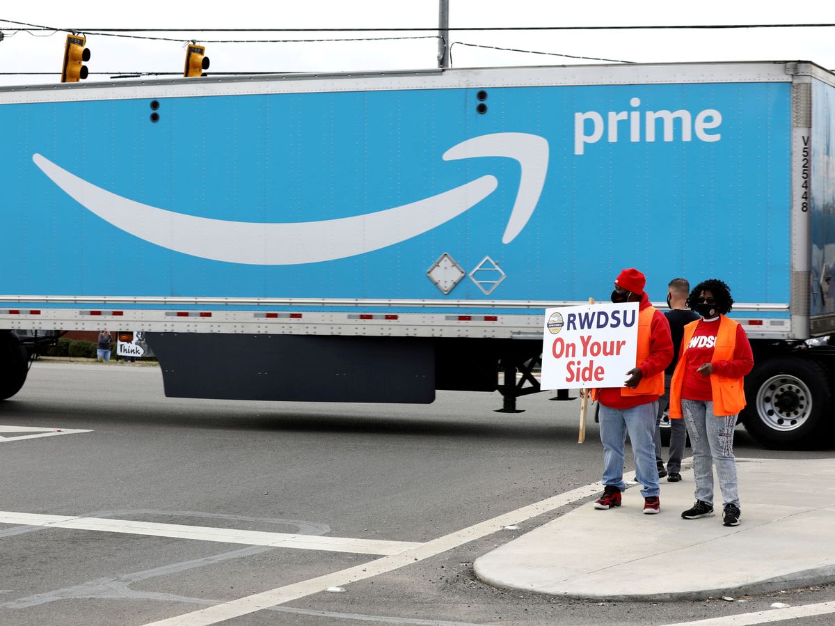 Foto: Personas sostienen una pancarta en las instalaciones de Amazon. (Reuters) 