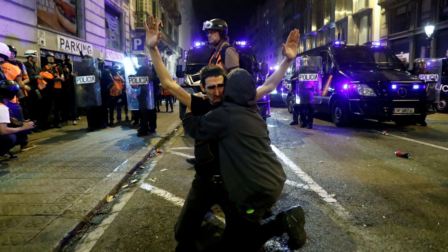 Un manifestante catalán recibe un abrazo mientras se arrodilla en el suelo durante la protesta del sábado. (Reuters)