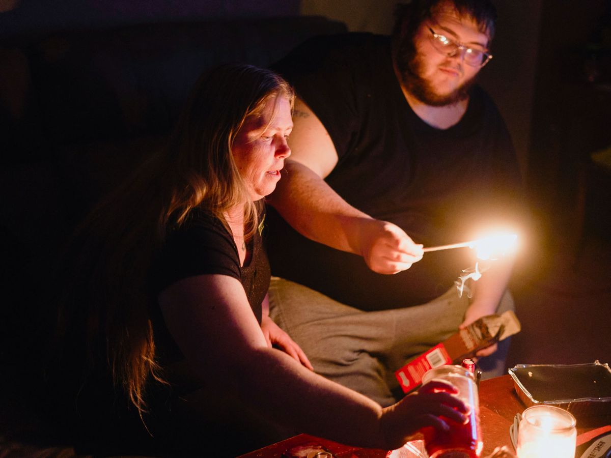 Foto: Dos ciudadanos encienden velas tras el temporal que provocó cortes de electricidad en Texas. (Reuters)