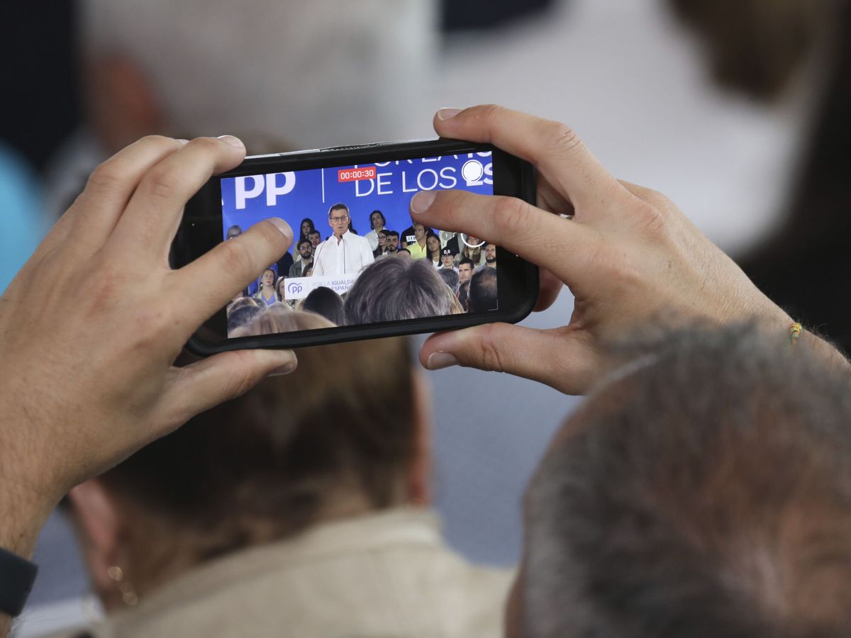 Foto: Un militante del PP graba un mitin de Feijóo. (EFE/Xoán Rey)