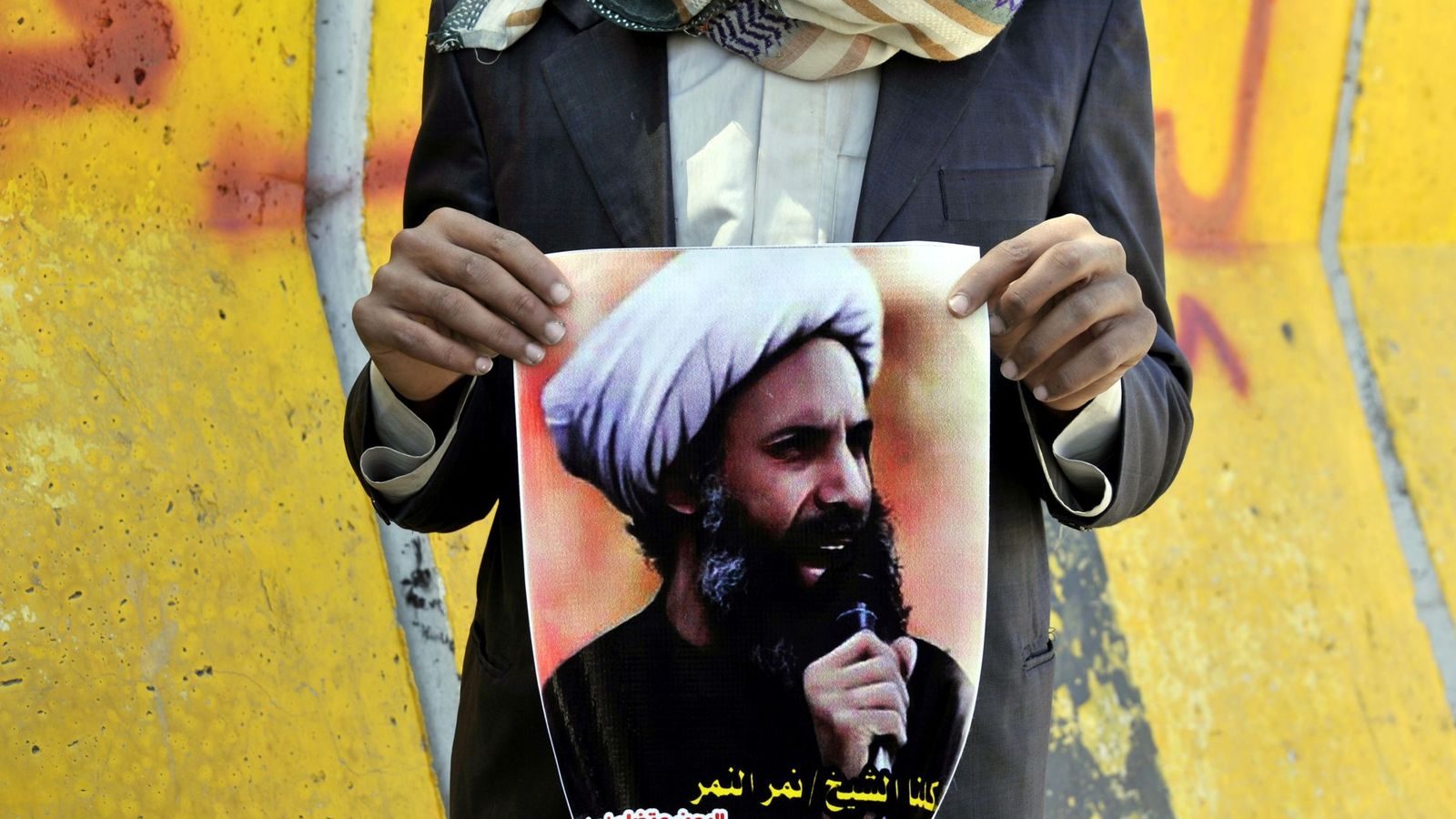 Foto: Imagen de octubre de 2014 de un participante en una protesta por la condena a muerte de Nimr Baqir al Nimr en Saná (Yemen), con un cartel del clérigo. (EFE)