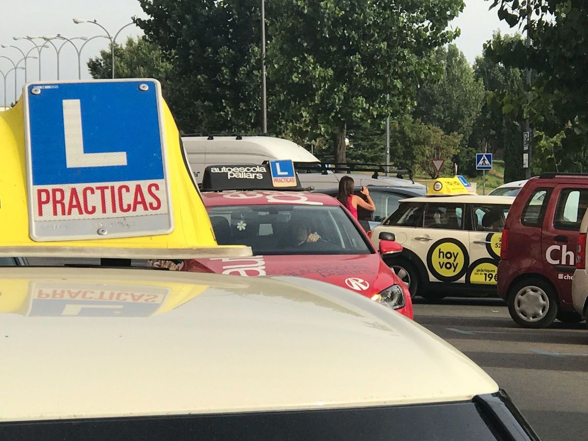 Foto: Varios vehículos de autoescuelas ante la sede de la DGT. (EFE / Ramón Gabriel)