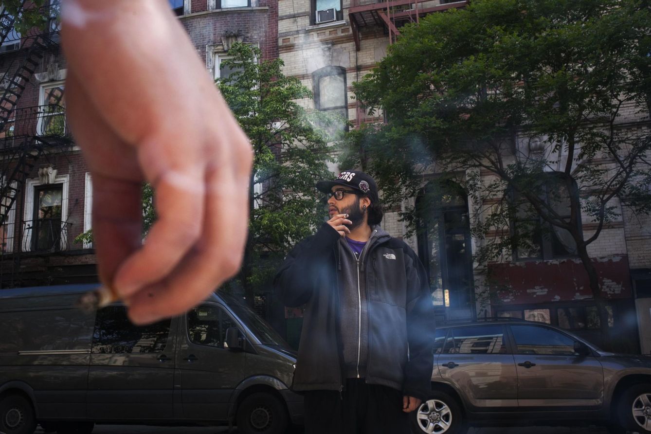 Un neoyorquino de 21 años fuma ante el apartamento de un amigo en Manhattan (Reuters).