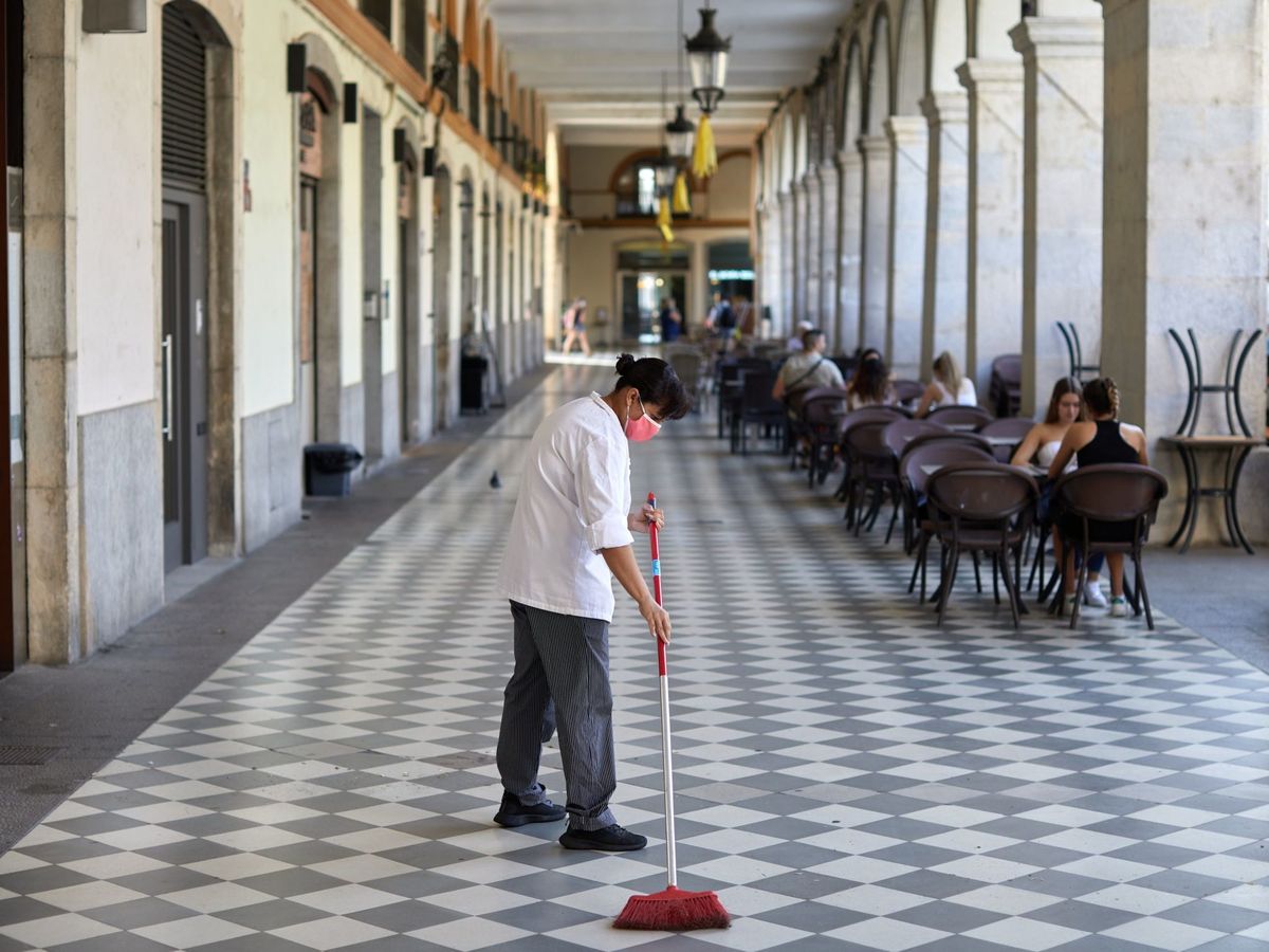Foto: Una trabajadora realiza tareas de limpieza en una plaza de Girona. (EFE)