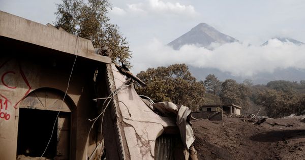 Foto: El Volcán de Fuego visto por detrás de unas viviendas dañadas por la erupción en El Rodeo, el 6 de junio de 2018. (Reuters)