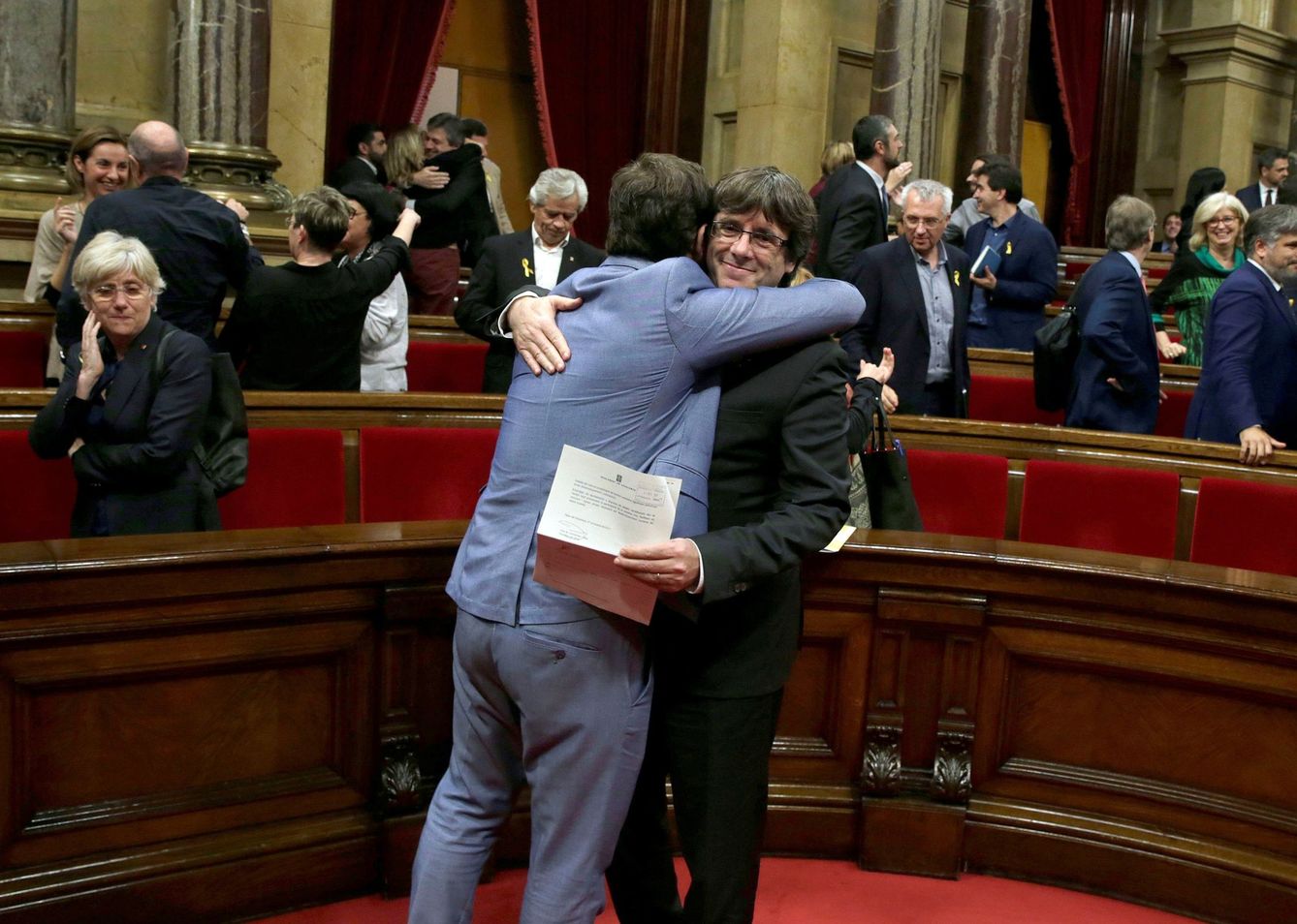 Carles Puigdemont es abrazado tras votar y aprobar la presunta aprobación de la DUI. (EFE)