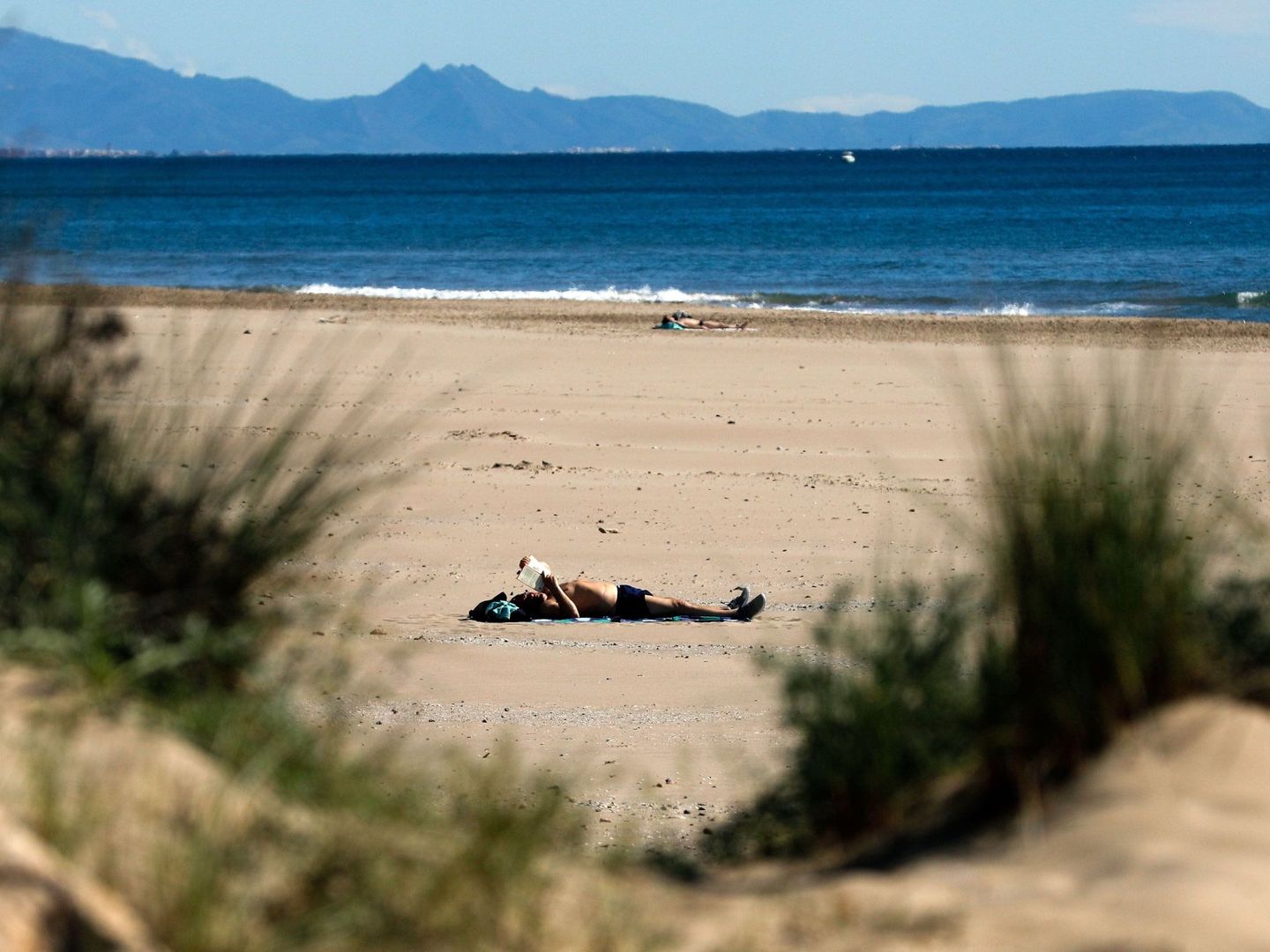 Una persona toma el sol en una playa de Sagunto, en Valencia. (EFE)