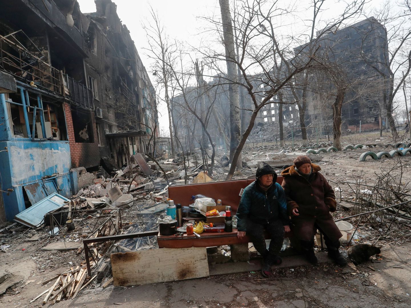 Residentes de Mariúpol frente a varios edificios en ruinas. (REUTERS Alexander Ermochenko)