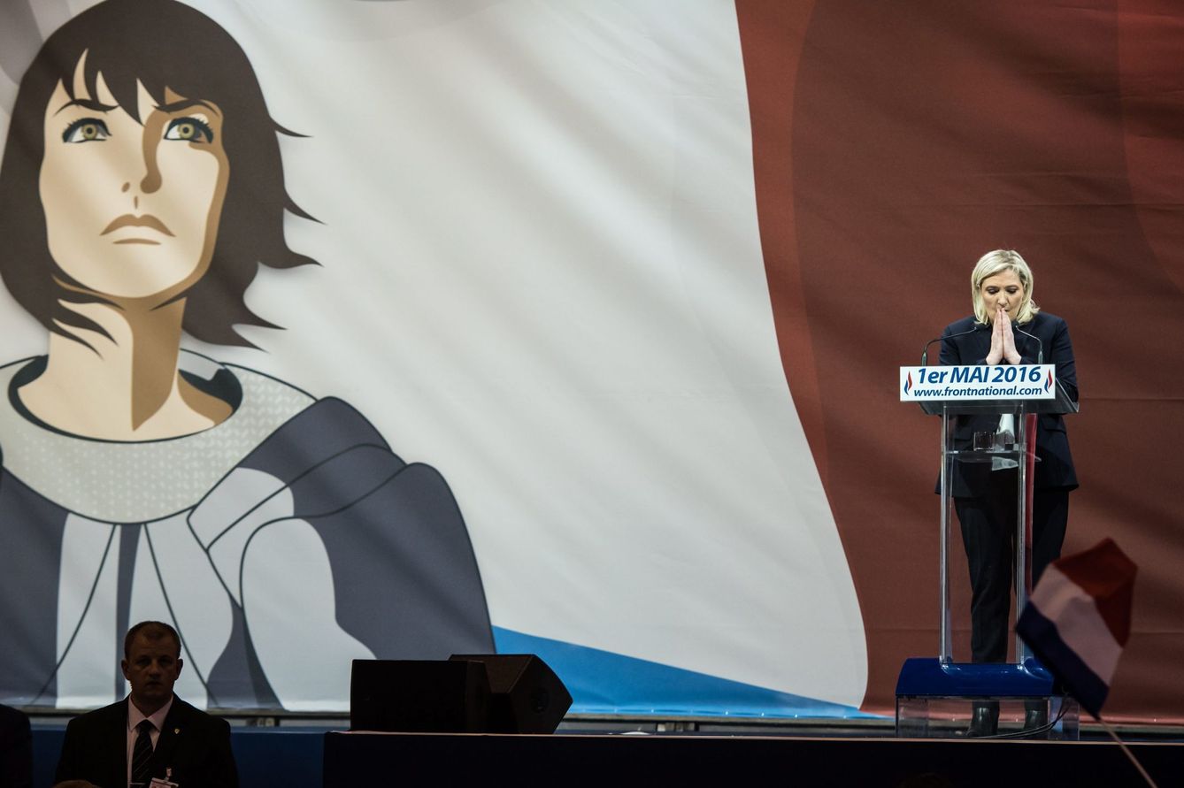 Marine Le Pen da un discurso con una pancarta de Juan de Arco. (Reuters)
