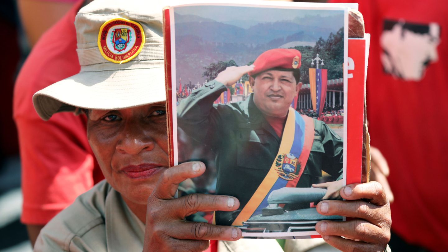 Una manifestante chavista durante la marcha de este sábado muestra una foto de Hugo Chávez. (Reuters)