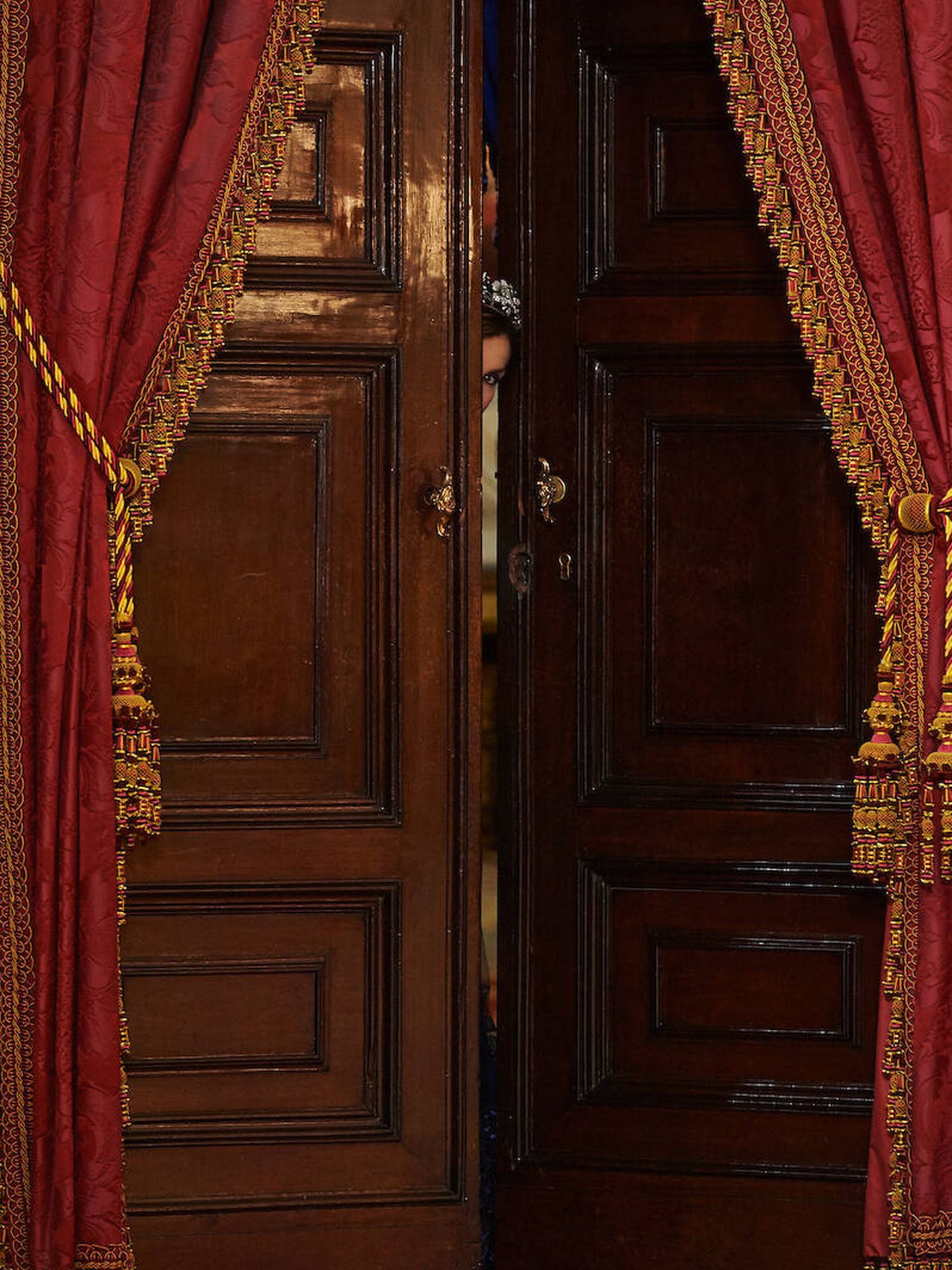 La reina Letizia, asomando la cabeza entre las puertas de Palacio. (LP/José Gegúndez)