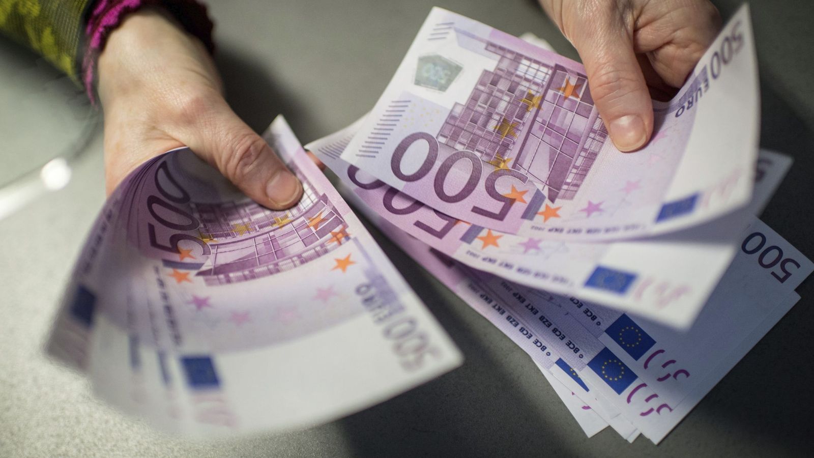 Foto: Un empleado de banca muestra 5.000 euros en billetes de 500. (EFE)