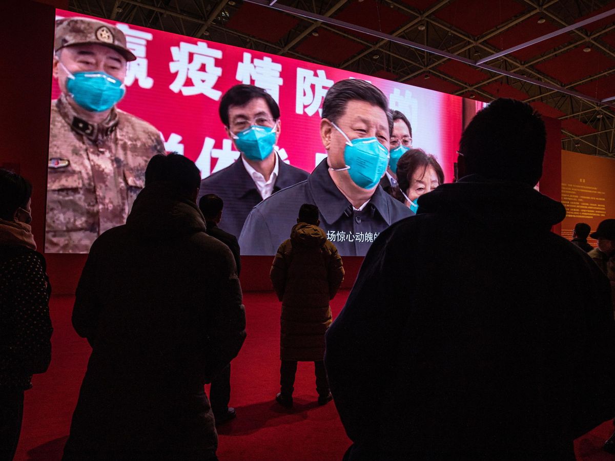 Foto: Varias personas, viendo un vídeo de Xi Jinping en Wuhan, China. (Reuters)