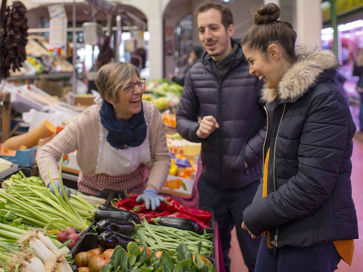 Foto: Carolina Sánchez e Iñaki Murua, en el mercado comprando verduras a Mari Carmen.