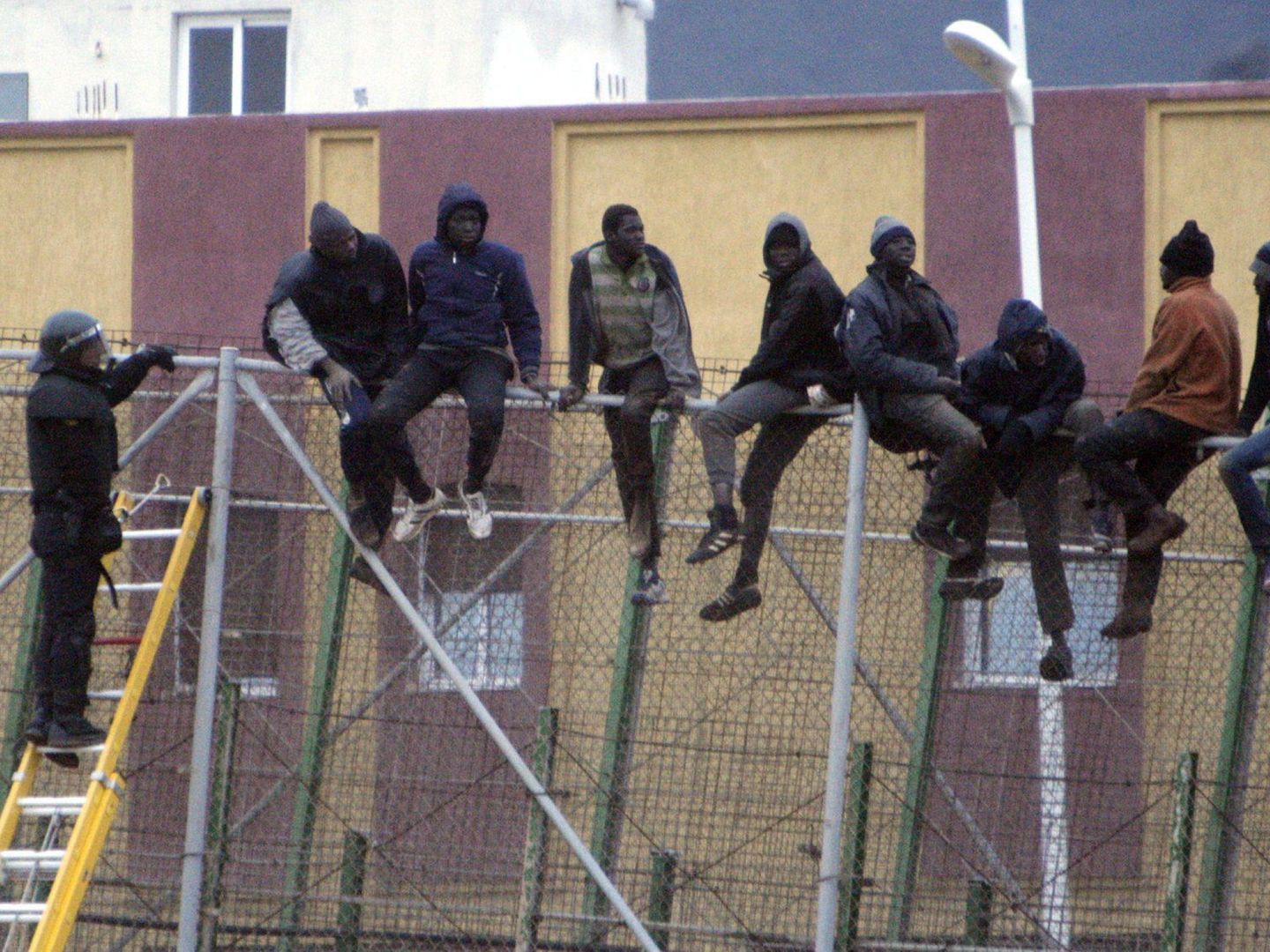 Una veintena de inmigrantes en la valla de Melilla. (EFE)